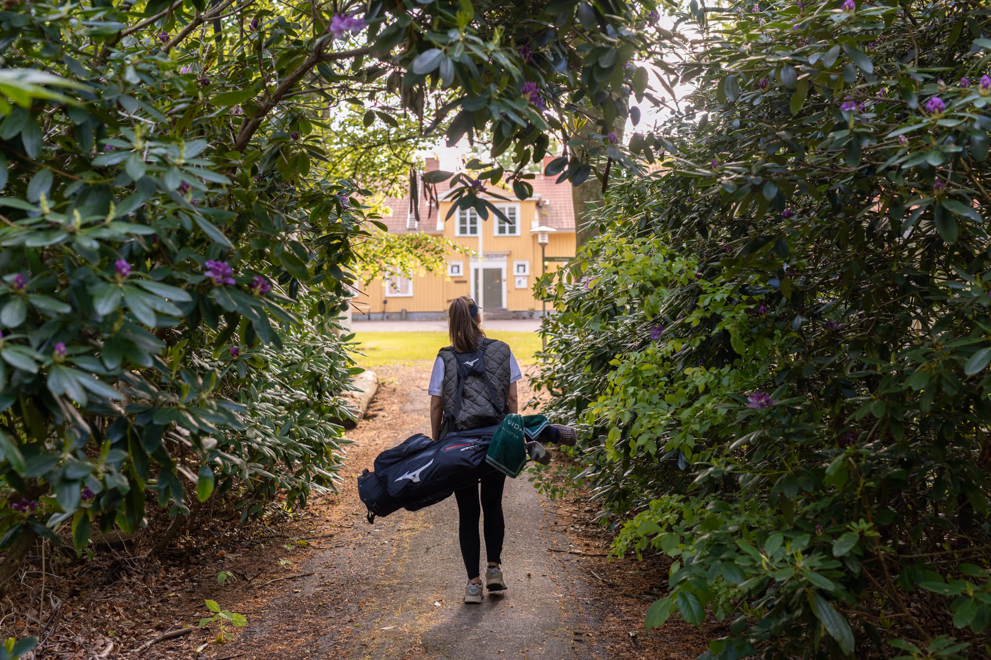 Gäst med golfbag på väg mot banan vid Lundsbrunn Resort & Spa